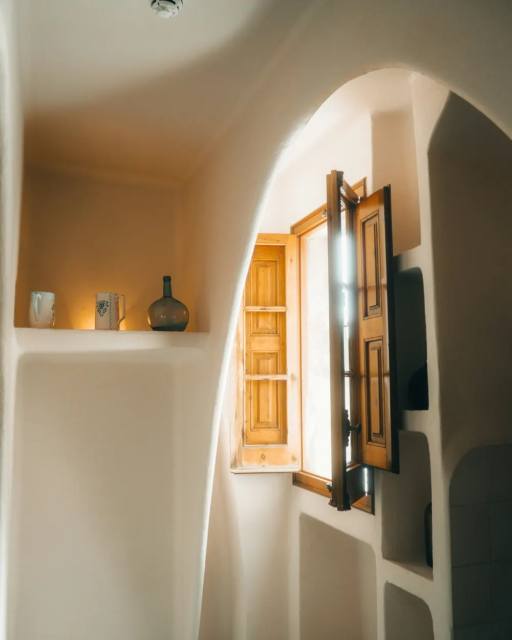 Luce calda che entra da una finestra con gli scuri in legno aperti